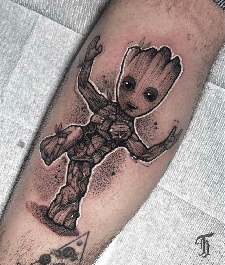 a man's leg with a tattoo on it and an image of a baby groot