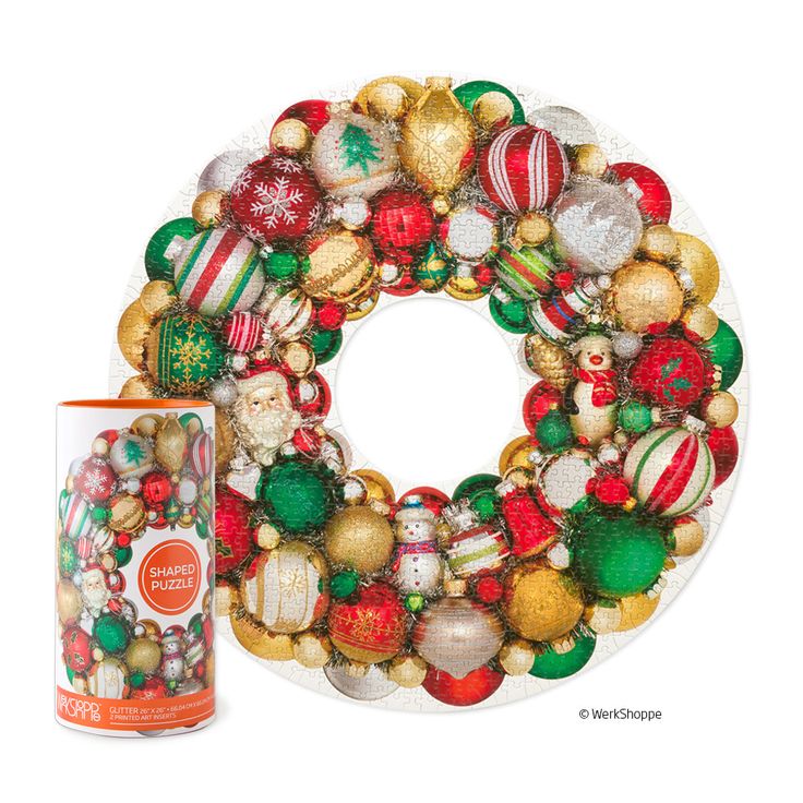 a christmas wreath next to a can of canned soda on a white background with an ornament in the shape of a wreath