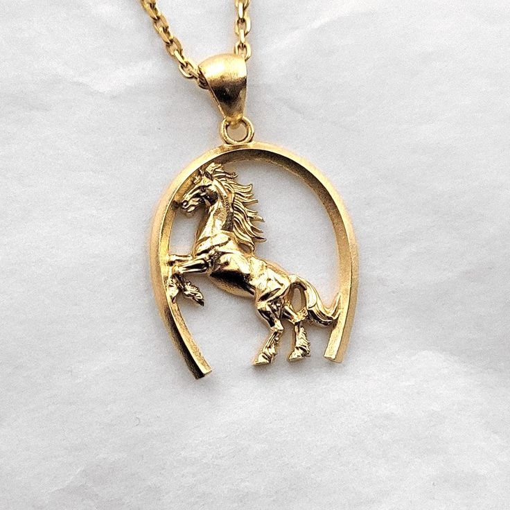 men's horse necklace pendant 1 made in 14k solid gold or 18k solid gold this necklace pendant is a horse with exquisite details in a horse's hoof. - pendant height is 28mm without the bail. - model wears a 2.1mm chain 50cm. - materials: 14k solid gold, 18k solid gold - designed by carre d'or - made in south korea 14k gold horse pendant necklace weight pendant only 7.66g (±5%) with a 2.1mm chain 42cm 13.62g (±5%) with a 2.4mm chain 42cm 15.49g (±5%) with a 3.0mm chain 42cm 19.24g (±5%) 18k gold horse pendant necklace weight pendant only 9.13g (±5%) with a 2.1mm chain 42cm 15.53g (±5%) with a 2.4mm chain 42cm 17.54g (±5%) with a 3.0mm chain 42cm 21.56g (±5%) Classic Horse Design Pendant Necklace, Gold Horse Design Pendant Necklace, Classic Gold Jewelry With Horse Design, Gold Pendant Necklace With Horse Design, 14k Yellow Gold Jewelry With Horse Design, Mens Necklace Gold, Men's Necklace Gold, Heirloom Rings, Horse Pendant