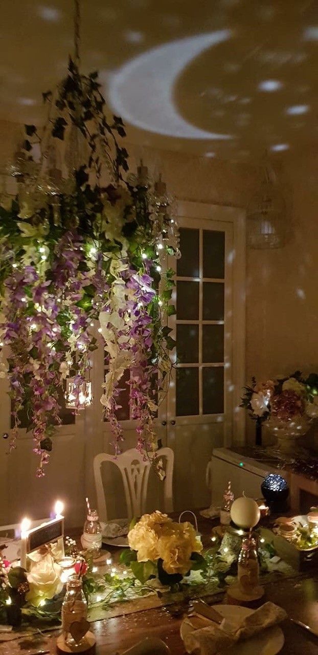 a dining room table covered in flowers and candles