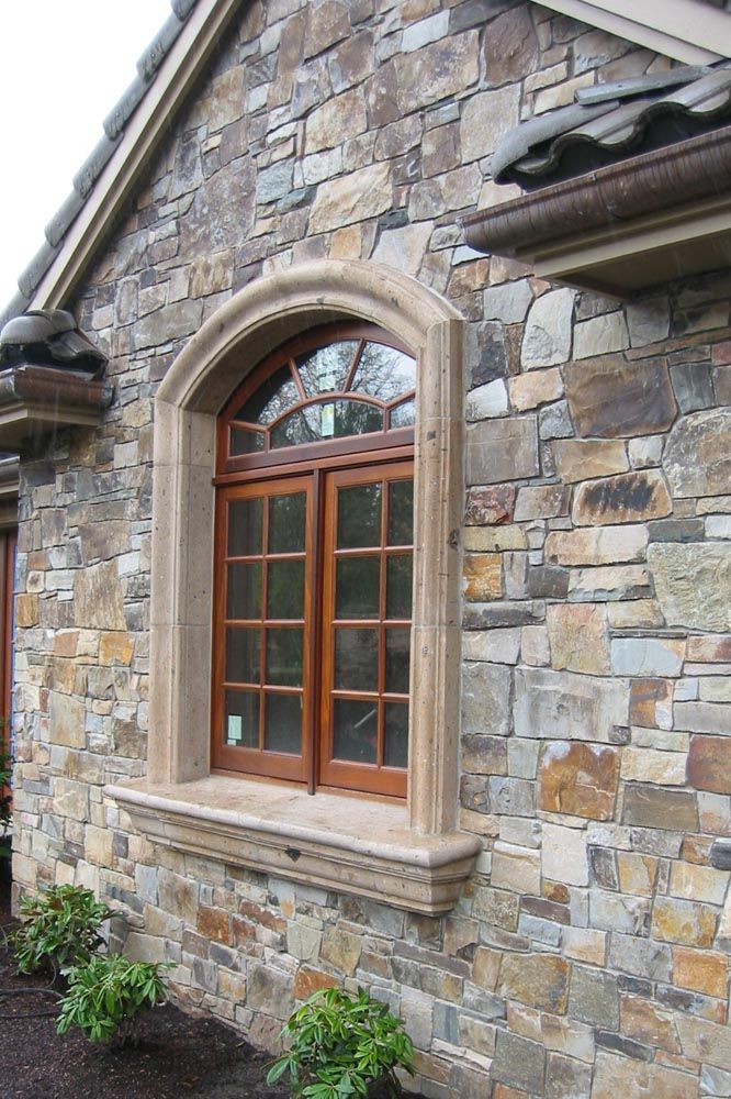 an arched window on the side of a stone building