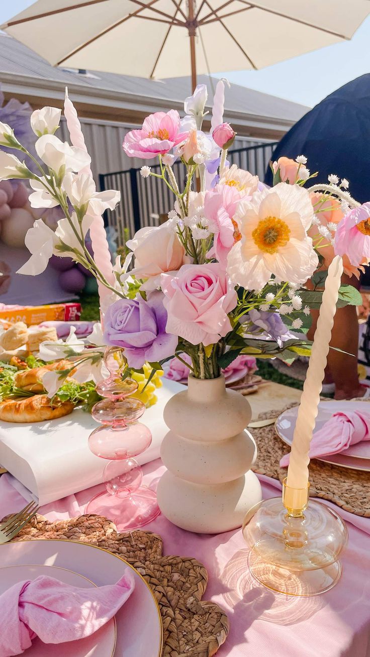 a table set with pink and white flowers