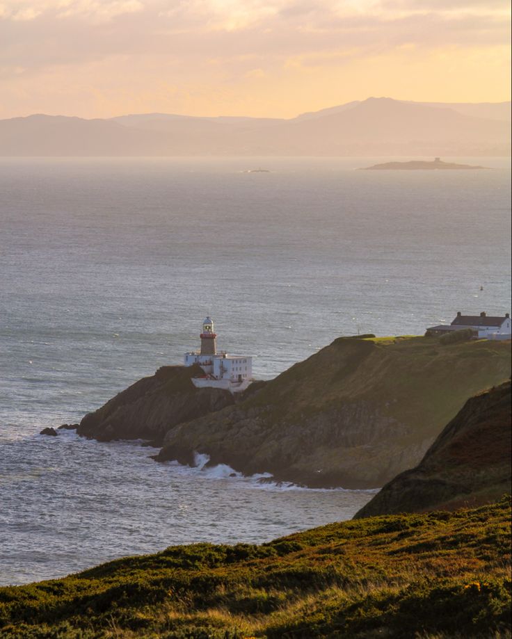 an ocean view with a lighthouse in the distance