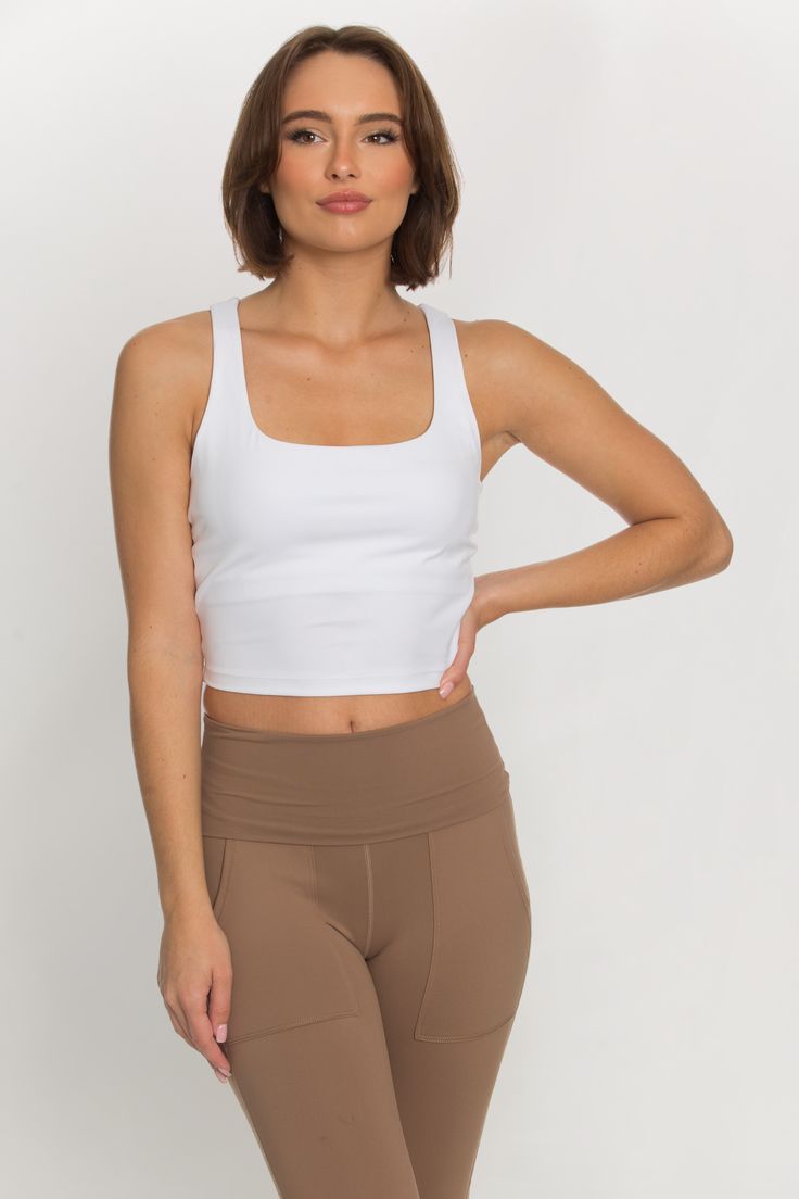 Our Whiteout Criss Cross Back Yoga Tank is our newest athletic tank and it is so flattering! It has a U-shaped front that offers coverage and a cute criss-cross style back. It features our ultra smooth, sweat-wicking material that you can wear when active or just out for the day! It is complete with built-in padding that can be removed if needed. 75% Nylon, 25% Spandex﻿ Built in / Removable Padding Model Details: Modeled in size: Small, Medium Model Waist: 25, 25 Model Bust: 32, 34 Model Height: Sporty Tank Top With Built-in Bra For Yoga, High Stretch Cross Back Tops For Gym, White Activewear With Built-in Bra For Everyday, Solid Cross-back Sports Top, High Stretch Cross Back Workout Top, Solid Color Cross-back Sports Top, Sporty High Stretch Cross Back Top, Athleisure Tank Top With Built-in Bra And 4-way Stretch, Athleisure Tank Top For Pilates With Tank Straps