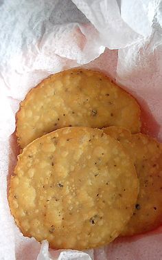 two crackers sitting on top of white paper in wrapper next to each other