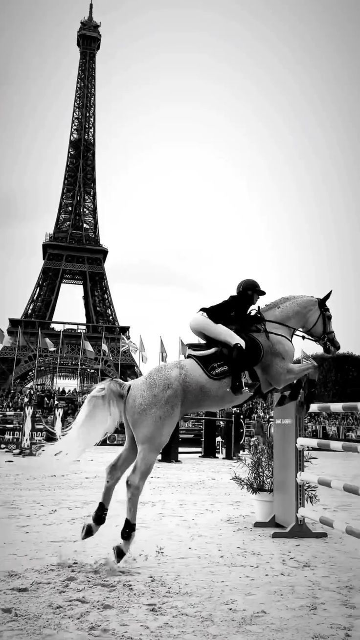 a person riding a horse in front of the eiffel tower