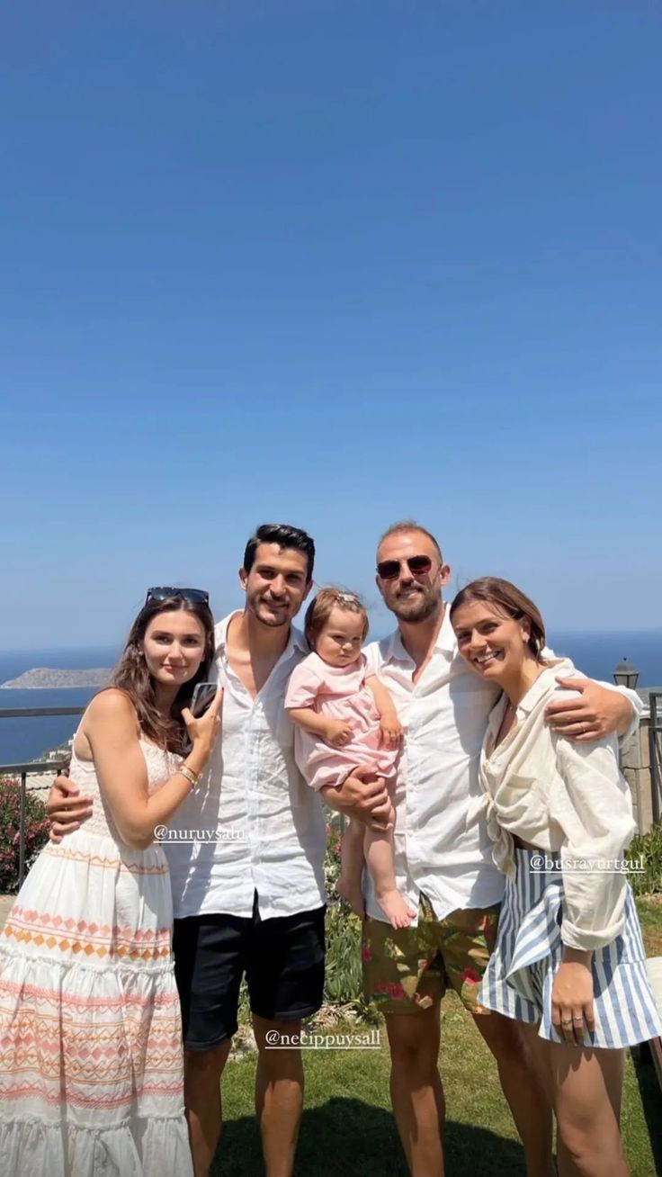 a family posing for a photo in front of the ocean