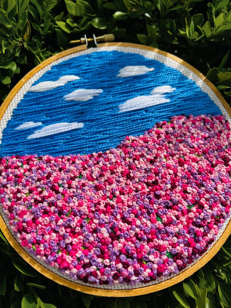 an embroidery project with flowers and clouds on it