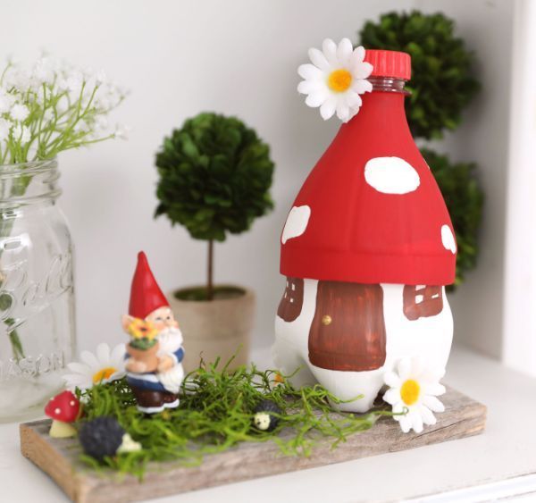 two gnomes are sitting on a shelf next to some plants