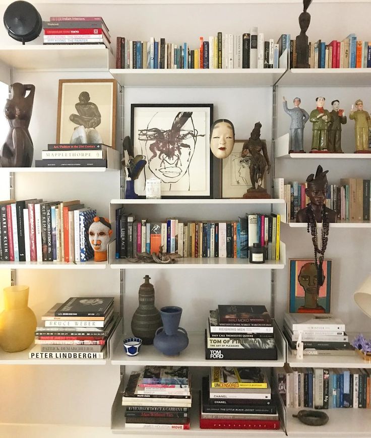 a bookshelf filled with lots of books and figurines on top of it