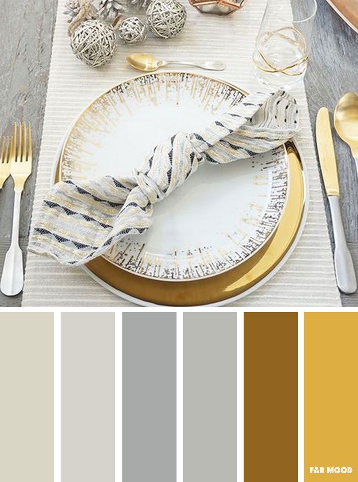 the table is set with silverware, gold and white plates, napkins, forks, spoons