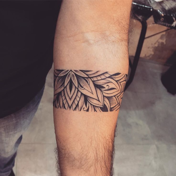 a man's arm with a tattoo on it that has leaves in the middle