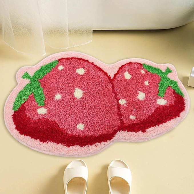 a pair of white shoes sitting next to a pink rug with two strawberries on it