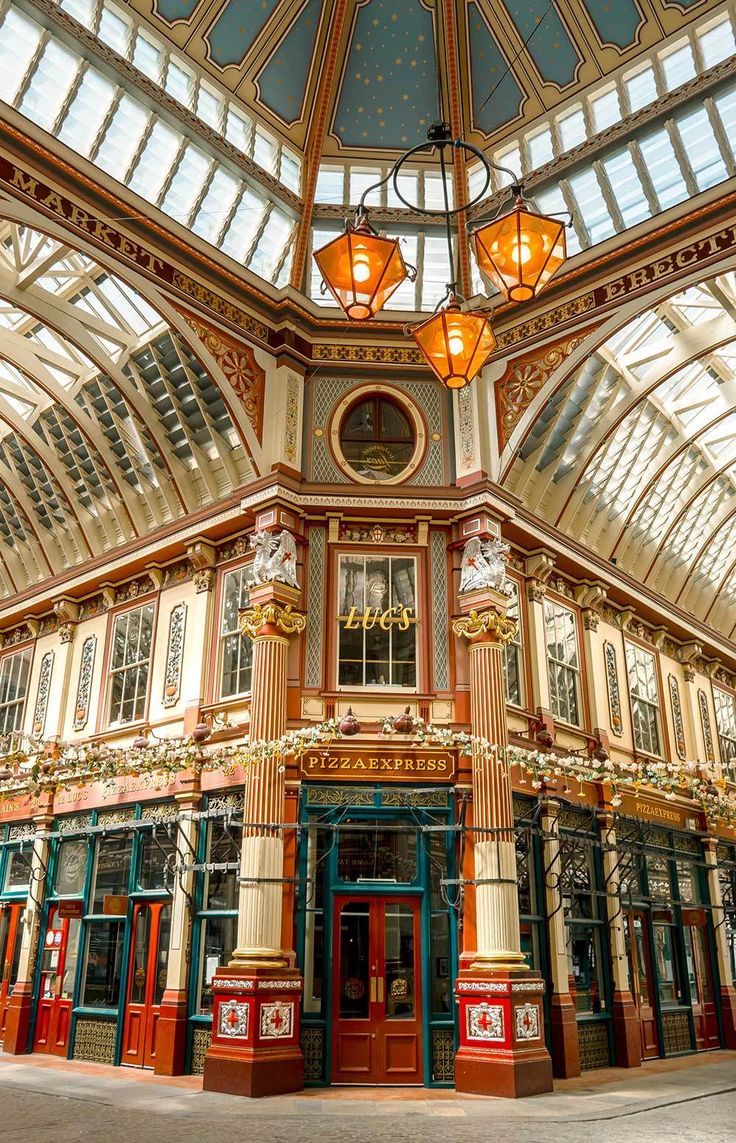 the inside of a building with many windows and lights hanging from it's ceiling