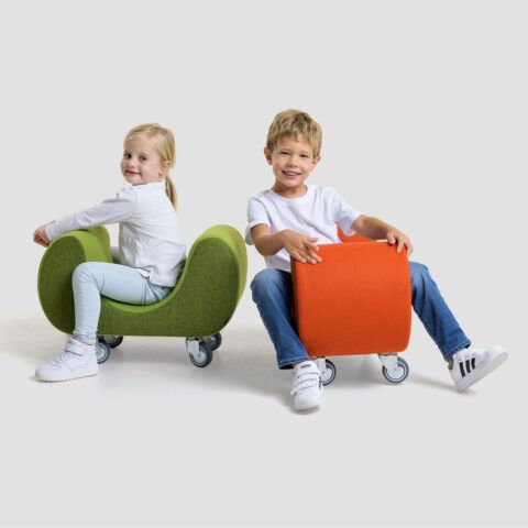 two young children sitting on different colored chairs