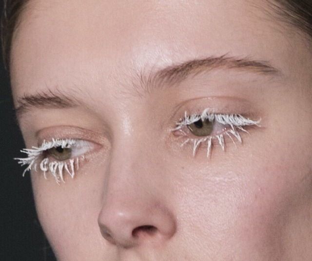 a woman's eyes with fake eyelashes on top of her nose and bottom half of her face