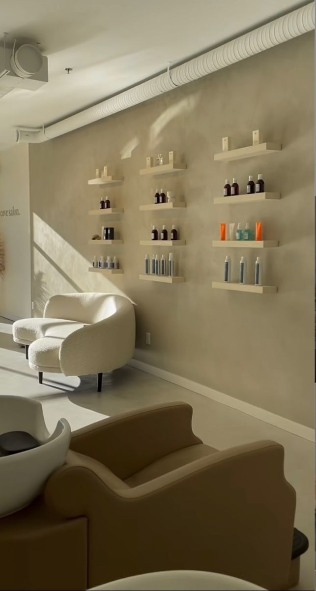 a salon with two chairs and shelves filled with hair care products on the wall behind them