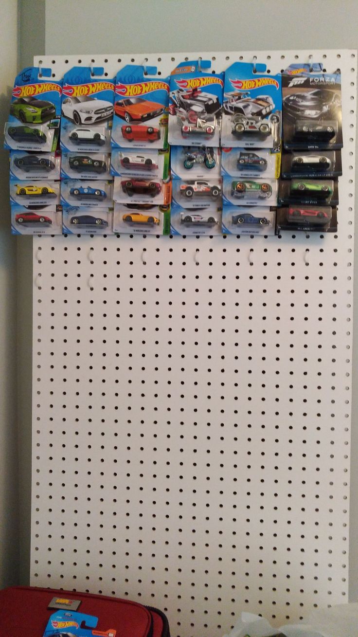 there are many toy cars on the pegboard