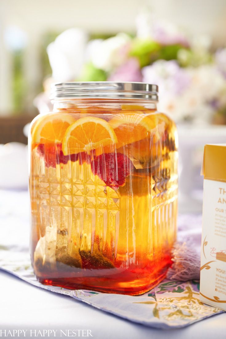 a jar filled with liquid sitting on top of a table next to a container of orange slices