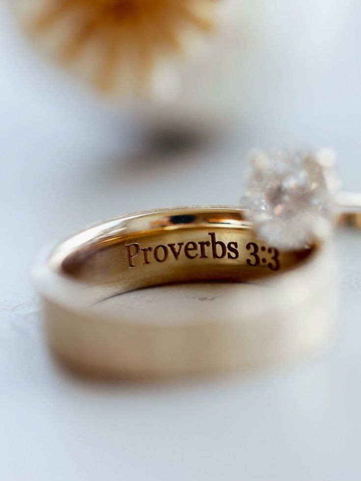 two wedding rings with the words proverbs 3 13 written on them