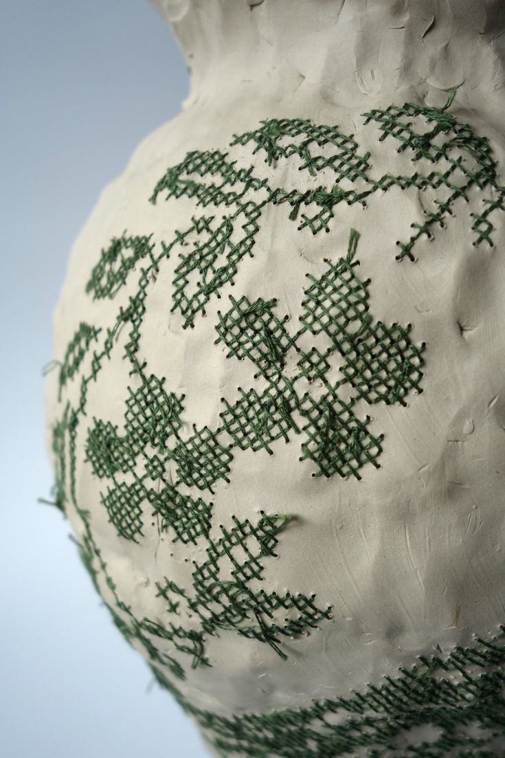 a green and white vase sitting on top of a table