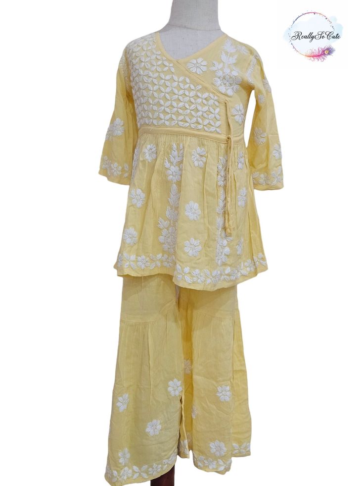 This is  super soft hand-embroidered chikankari angarakha style Kurti, sharara set for your little ones. It gives a very smooth feel to your skin and hand embroidery on this Kurti makes it set apart from other Kurtis. It is a premium quality fabric with hand work all over the set. TOP Fabric - Premium Modal Neck Type: Round Neck BOTTOM FABRIC- Modal with hand embroidery  Please note : DUPATTA is  NOT included. Please check measurements to ensure fitting. Size - 1) 2-3 year (size 18) Kurti length: 17.5 inches approx  Sharara length: 19.5 inches approx Chest: 20 inches approx 2) 5-6 year (size 26) Kurti length: 26 inches approx  Sharara length: 25 inches approx Chest: 28 inches approx 3) 8-9 year (size 30) Kurti length: 28.5 inches approx  Sharara length: 29 inches approx Chest: 30 inches ap Bollywood Style Sharara With Cutdana For Spring, Anarkali Sharara With Cutdana For Spring, Spring Anarkali Sharara With Cutdana, Traditional Spring Sharara With Dori Work, Spring Cotton Sharara With Zari Work, Cotton Sharara With Floral Embroidery For Diwali, Yellow Sharara With Chikankari Embroidery For Spring, Traditional Cotton Sharara With Floral Embroidery, Yellow Cotton Anarkali Set With Floral Embroidery