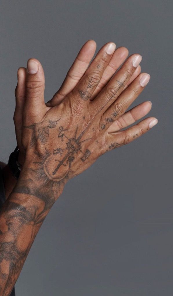 a close up of a person's hands with tattoos on their arms and chest