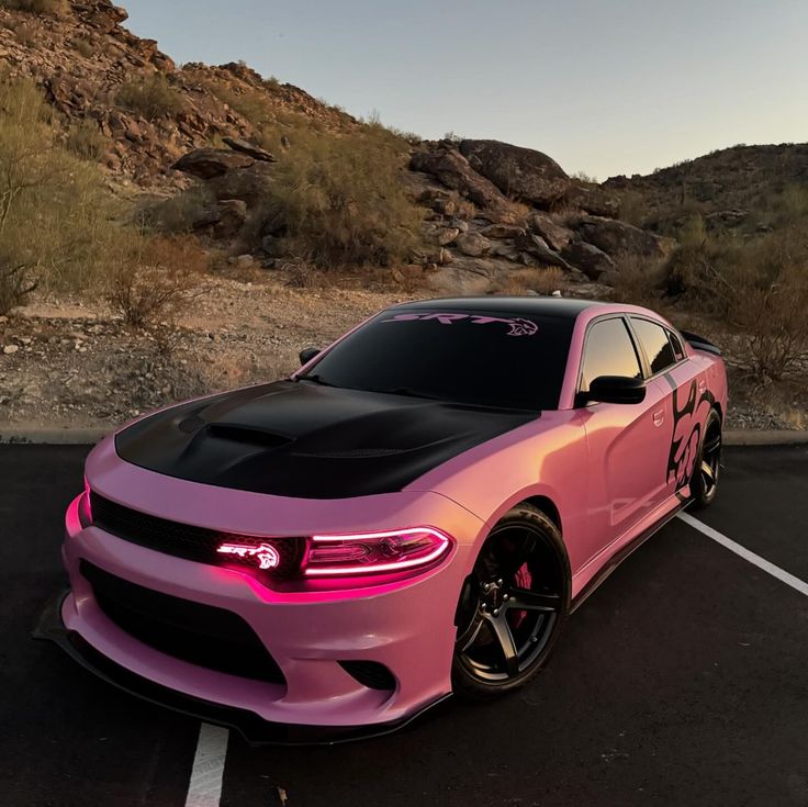 a pink and black car parked in a parking lot