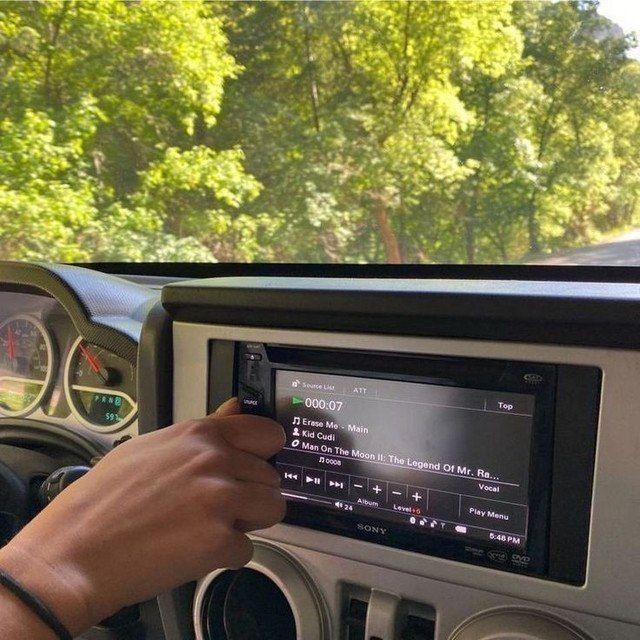 a man driving a car while holding the steering wheel