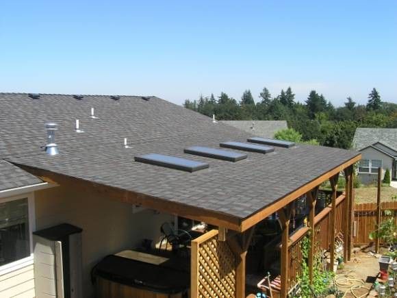 an overhead view of a house with solar panels on the roof and plants growing in the yard