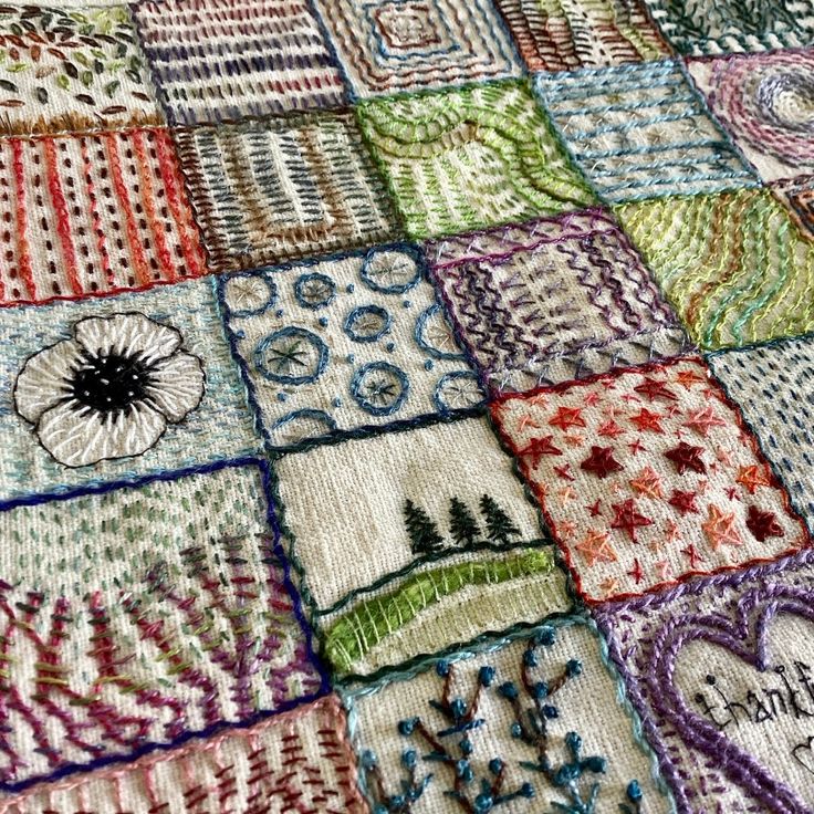 a close up of a quilt with many different designs on it