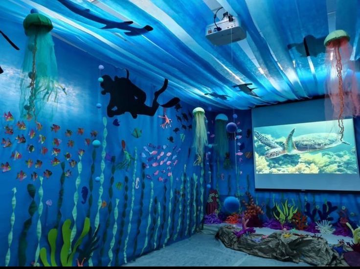 an underwater themed room with blue walls and under water decorations on the ceiling, along with various sea creatures