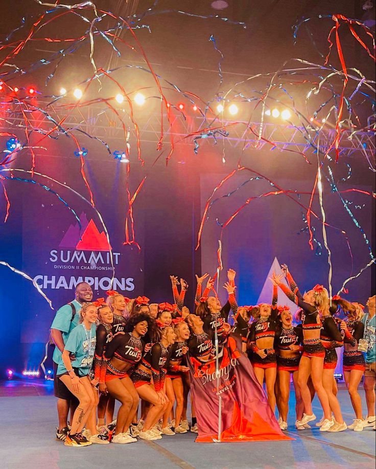 a group of women standing on top of a stage with confetti in the air