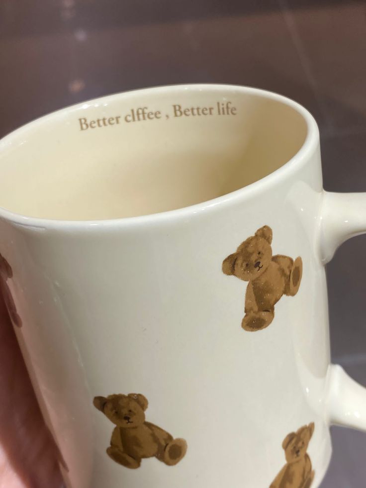 a hand holding a coffee mug with brown teddy bears on it's side and the words better life, better life