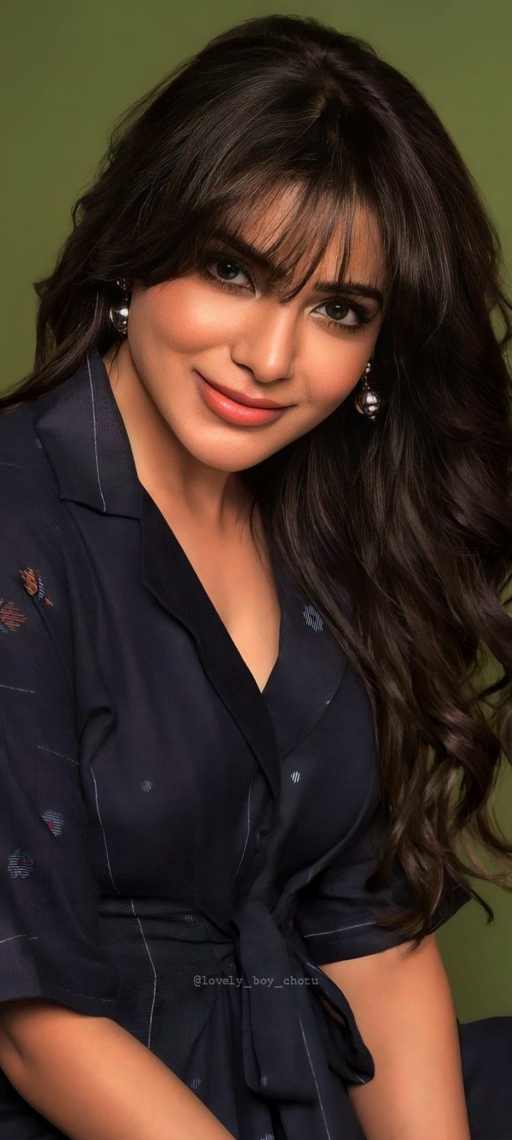 a woman with long dark hair posing for the camera