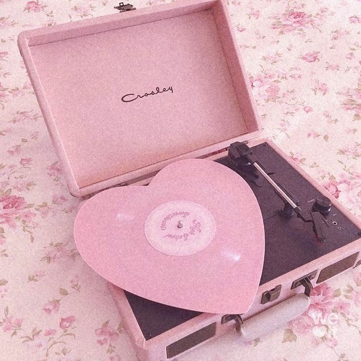 a pink record player sitting on top of a table