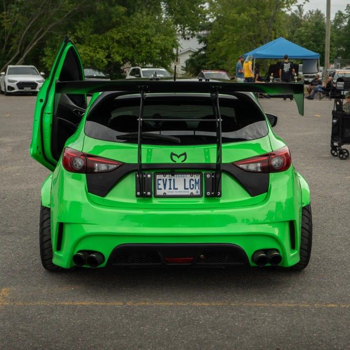 the back end of a green sports car parked in a parking lot