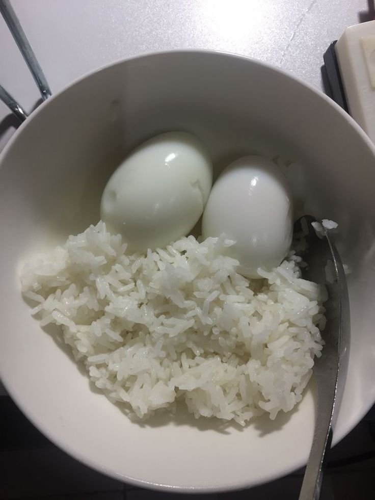 two eggs and rice in a white bowl