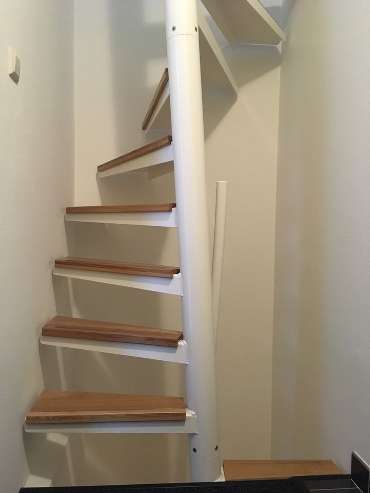 there is a stair case in the corner of this room with no carpet on the floor