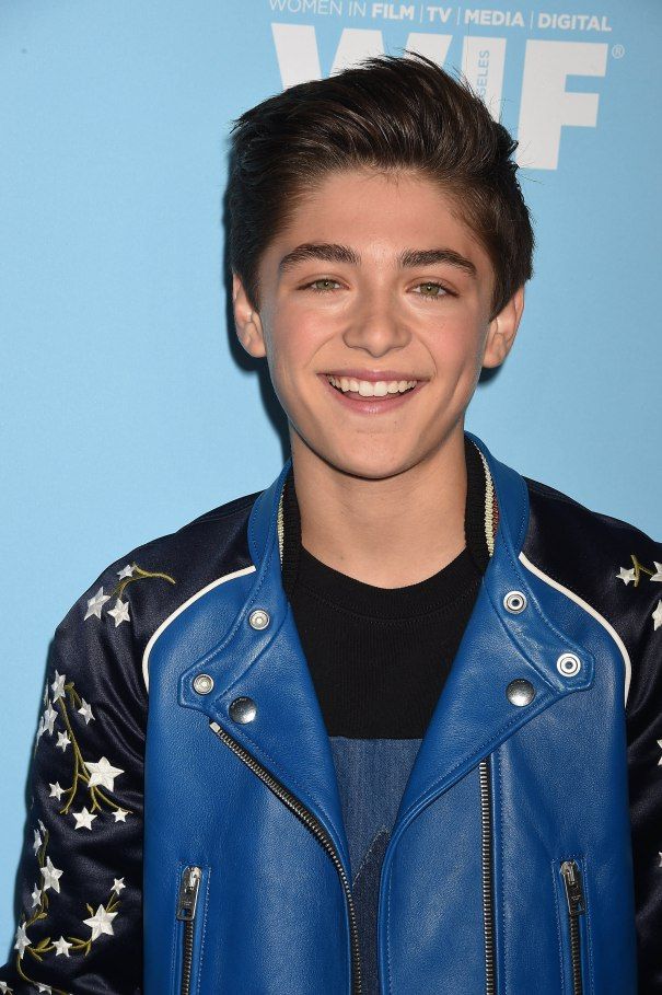 a young man wearing a blue leather jacket