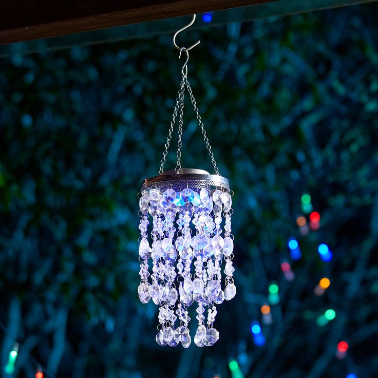 a chandelier hanging from a chain with lights in the background