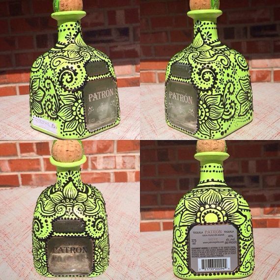 four green glass bottles with designs on them