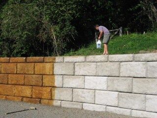 a man standing on top of a block wall