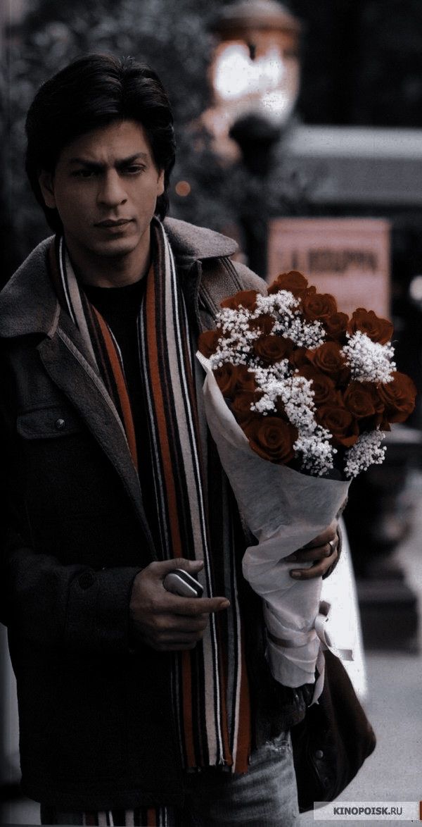 a man walking down the street holding a bouquet of flowers