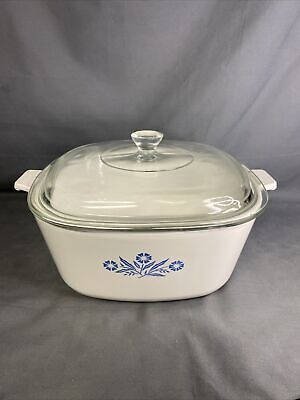 a casserole dish with a glass lid and blue flowers on the side,