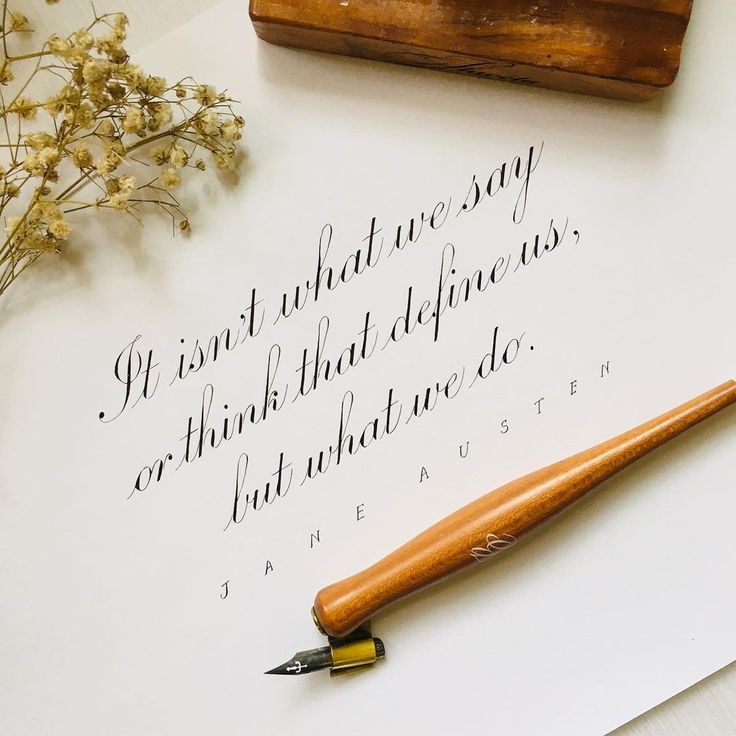 a fountain pen sitting on top of a piece of paper next to a wooden stamper