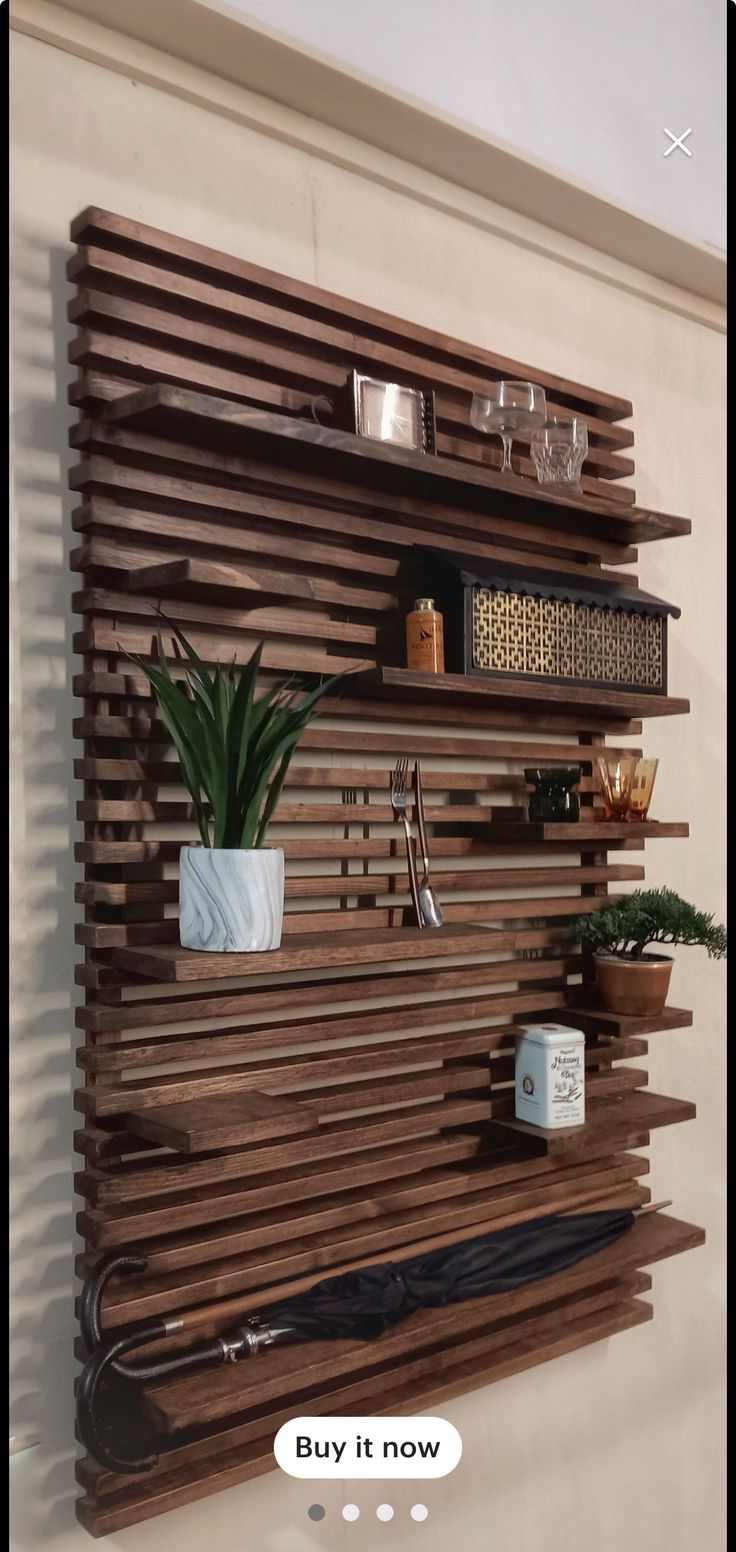 a wooden shelf with plants and other items on it that is attached to the wall