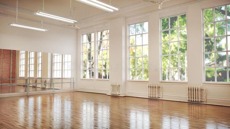 an empty room with large windows and hard wood floors