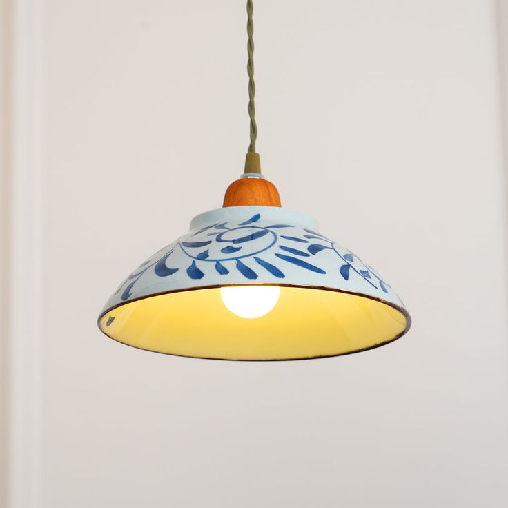 a blue and white light hanging from a ceiling fixture with an orange cord attached to it