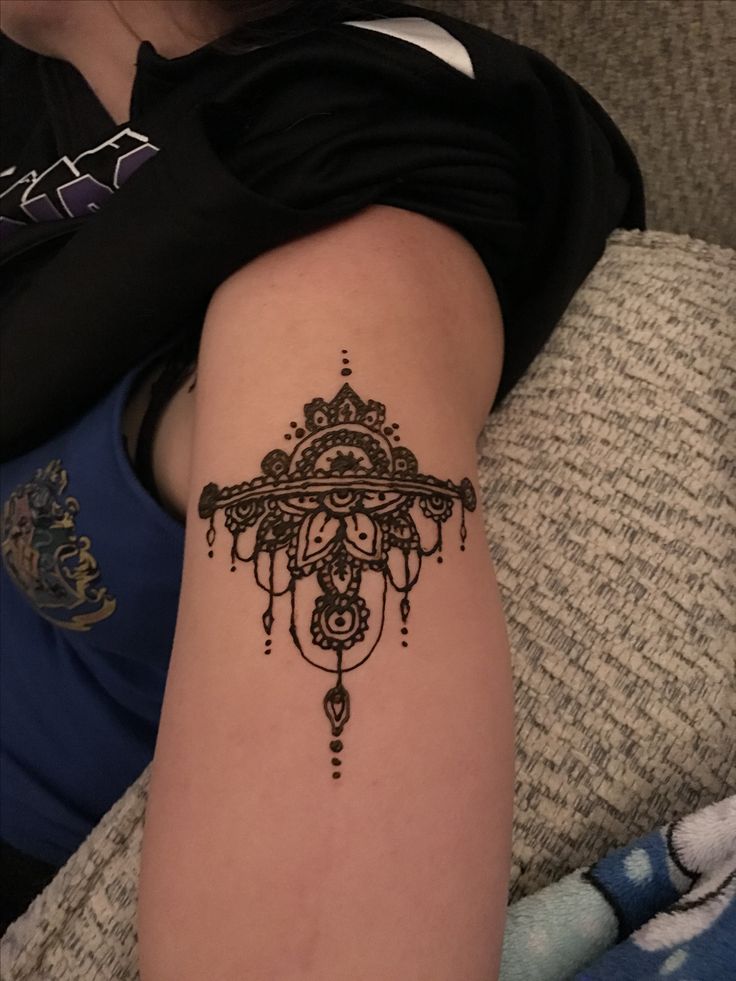 a woman's arm with a tattoo on it that has a cross in the middle